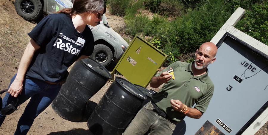Photo of Brieana Weaver and Rob Pincus as he demonstrates tool to keep door open